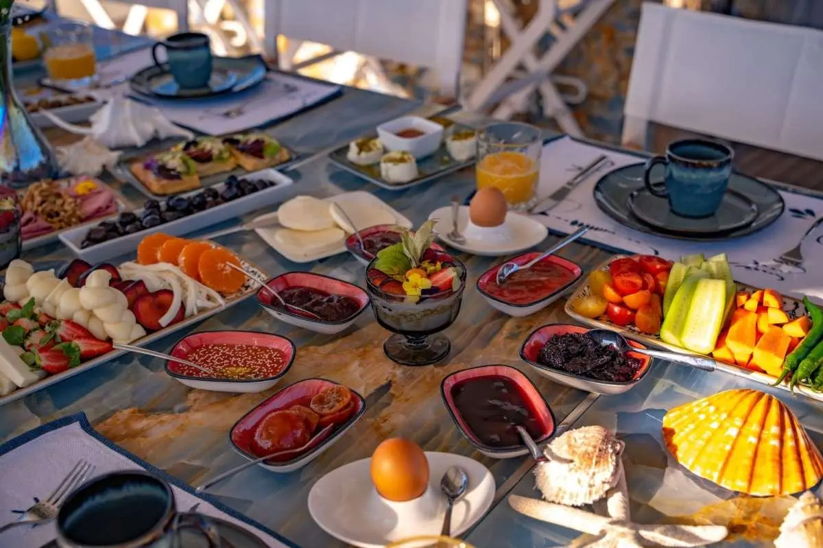 Elegant table set for a meal on a yacht, fresh fruit and drinks visible