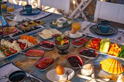 Elegant table set for a meal on a yacht, fresh fruit and drinks visible