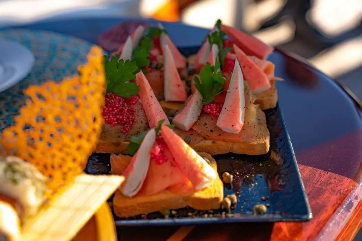 Yacht Double Eagle menu items on a plate with sliced fruit and decor