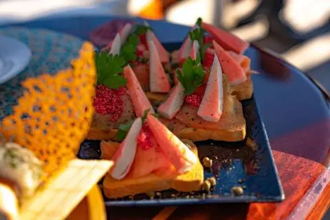 Yacht Double Eagle menu items on a plate with sliced fruit and decor