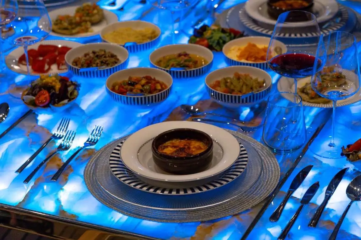 Yacht Double Eagle dining setup with plates and beverages on a blue deck
