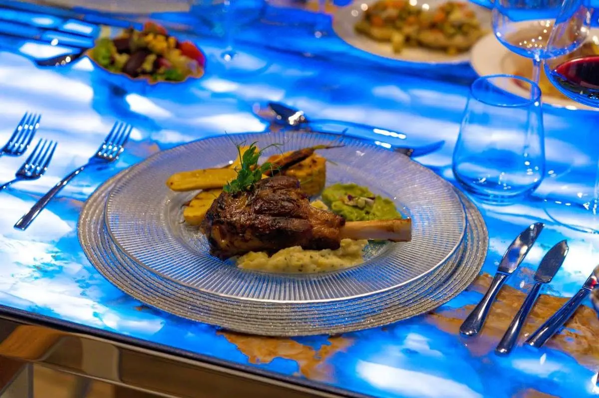 Double Eagle yacht interior table setting with plated meal and blue patterned tablecloth