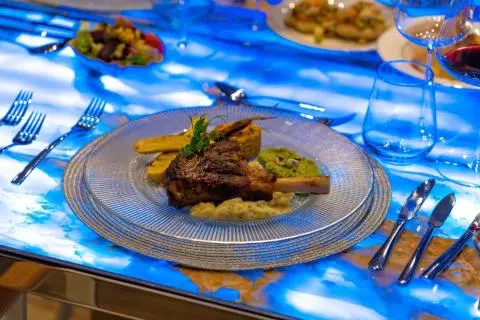 Double Eagle yacht interior table setting with plated meal and blue patterned tablecloth