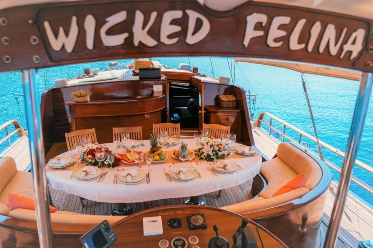 Overview of Wicked Felina yacht deck with lounging seating and round dining area