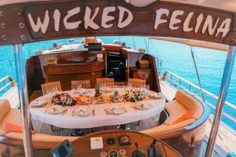 Overview of Wicked Felina yacht deck with lounging seating and round dining area