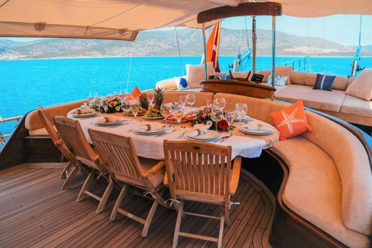 Wicked Felina yacht deck with sun loungers and dining table setup by poolside