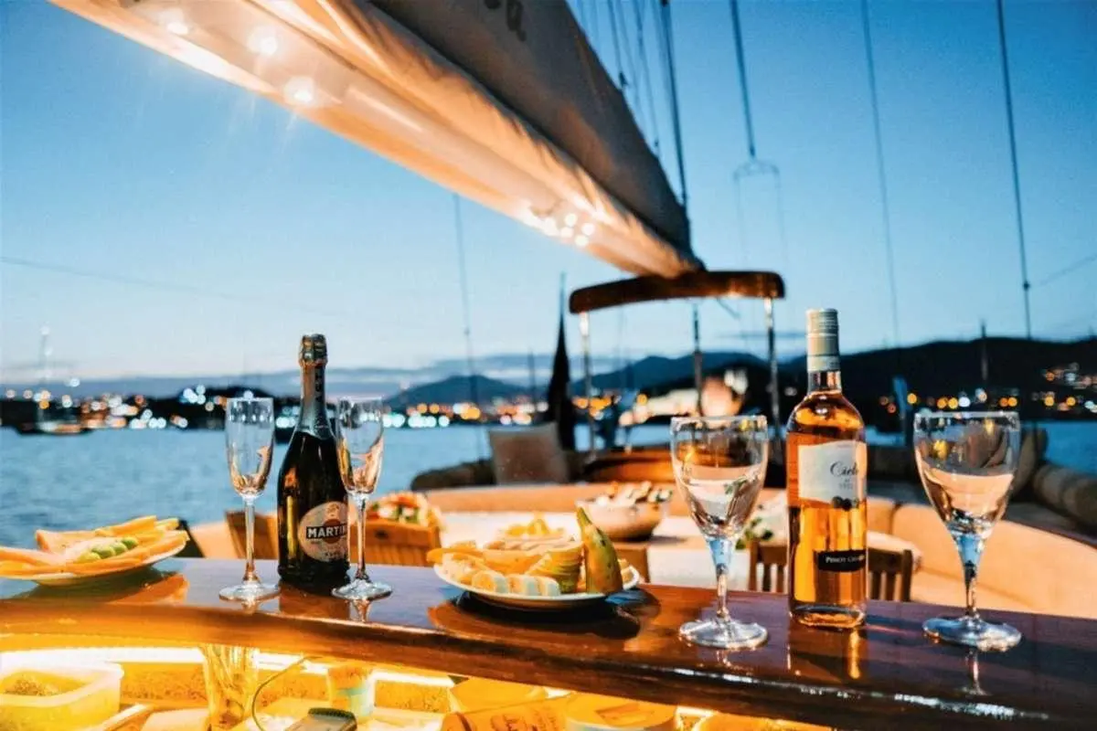 Wicked Felina yacht deck scene with sunlit wooden railings and crewed seating