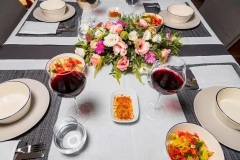 Overhead table setting on Bodrum Queen yacht with flowers, plates, and drinks