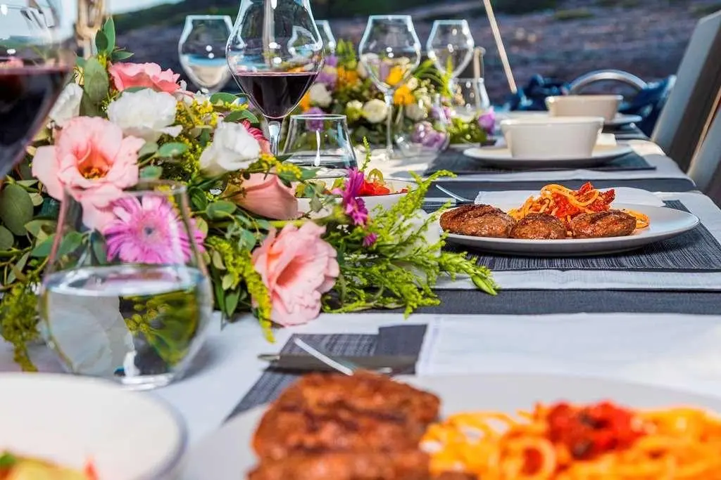 Table setup on deck with dishes, flowers, and beverages on Bodrum Queen yacht