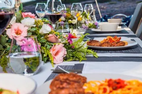 Table setup on deck with dishes, flowers, and beverages on Bodrum Queen yacht