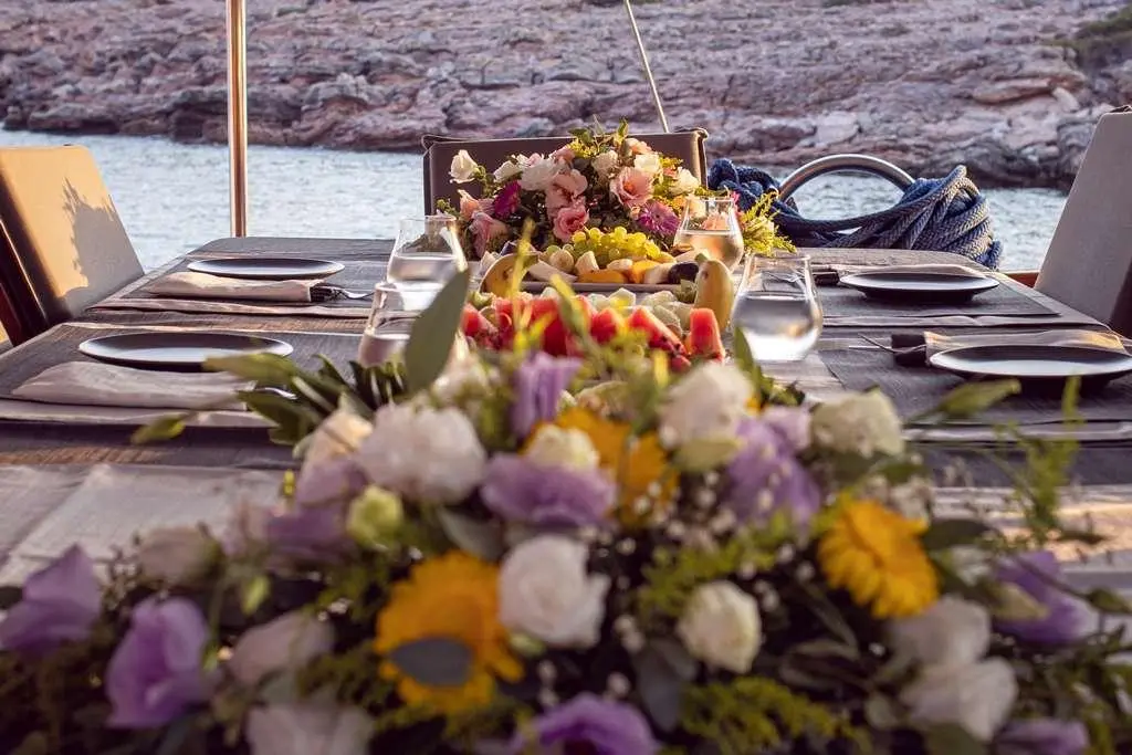 Deck view with a floral centerpiece aboard Bodrum Queen yacht at sea