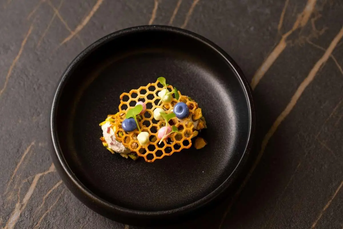 Top-down view of a sizzling pan with a small cluster of colorful fried macaroni shapes