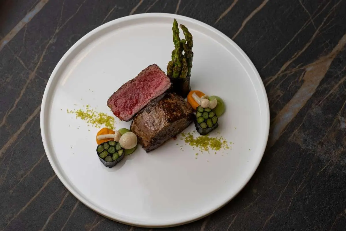 Love Story yacht dining plate with two meat mains and greens on white plate