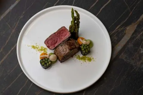 Love Story yacht dining plate with two meat mains and greens on white plate