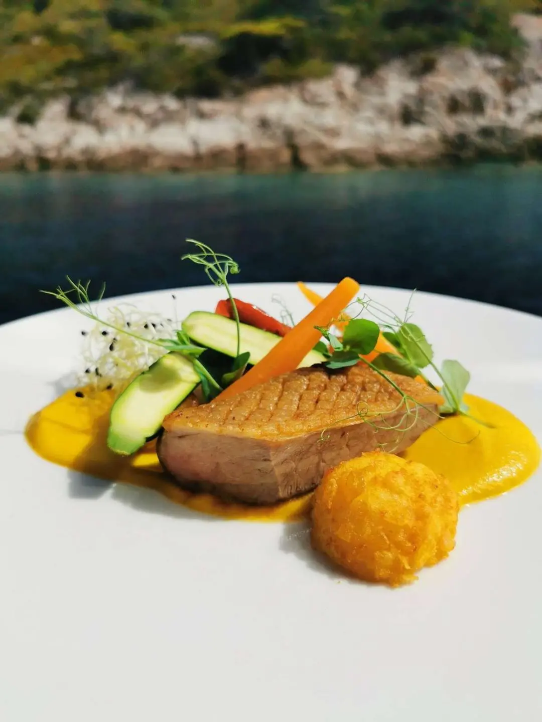 Corsario yacht menu dish served on plate with vegetables and lemon wedges
