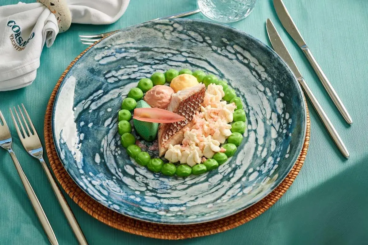 Corsario yacht menu dish photographed on table with turquoise glass plate