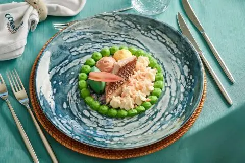 Corsario yacht menu dish photographed on table with turquoise glass plate