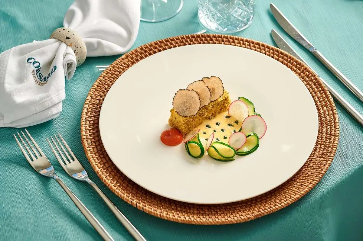 Corsario yacht menu plate with oysters and cucumber slices on teal table