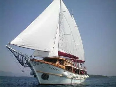Cataleya yacht with white sails unfurled on blue sea during daylight