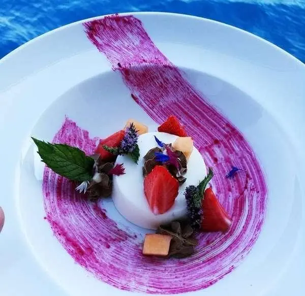 Libra yacht charter: dessert plate on a tiny table by pool with pink sauce