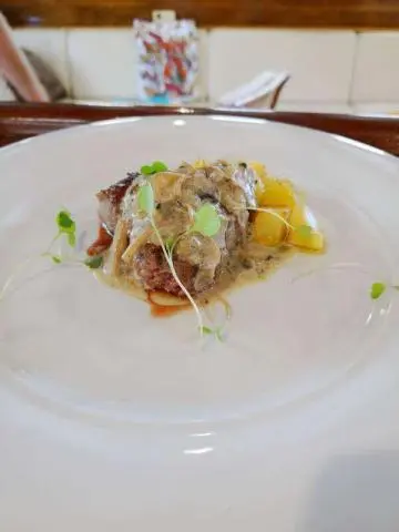 Libra yacht image showing a plated dish with sauce, greens, and garnish