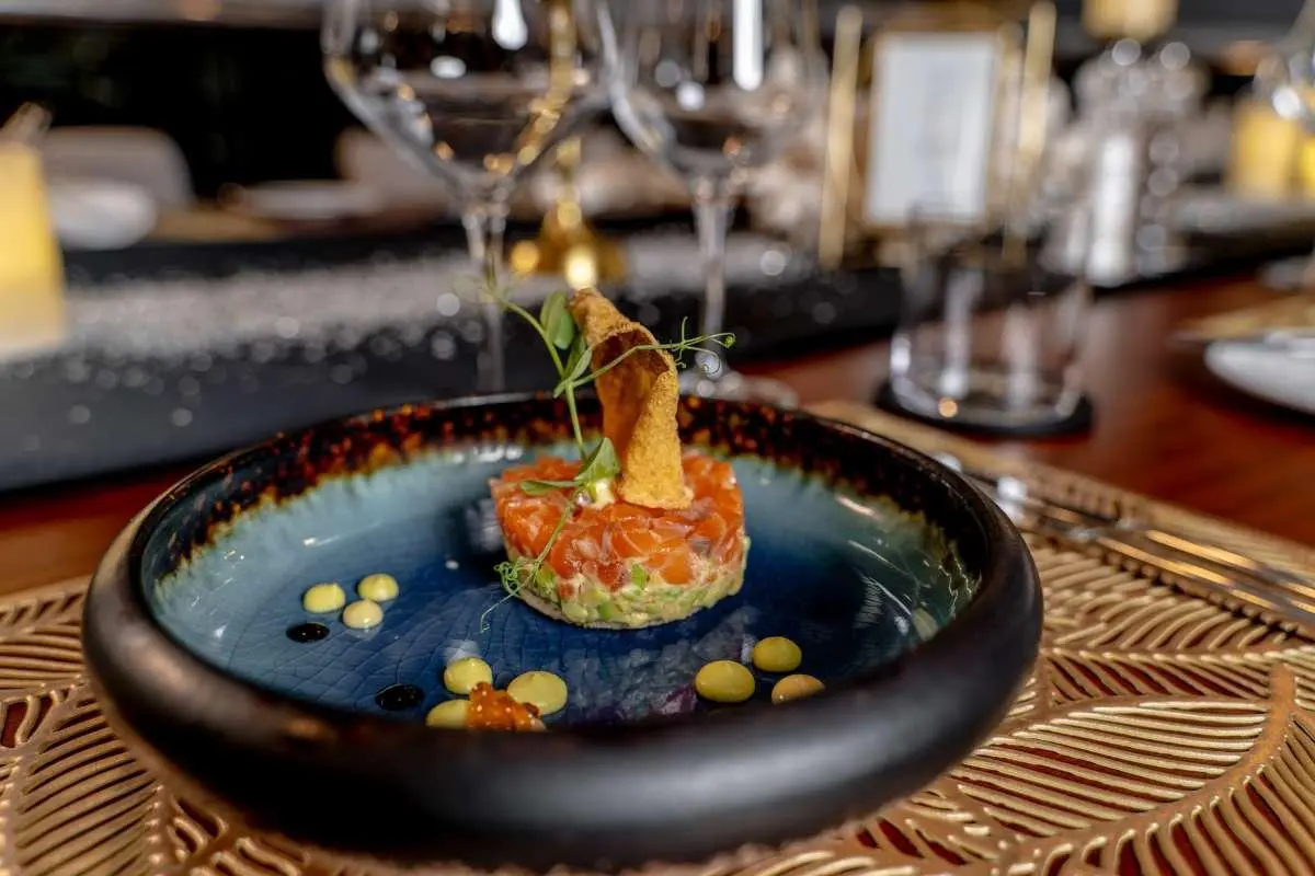 Close-up of a carved orange fruit centerpiece with a blue decorative plate on a yacht table