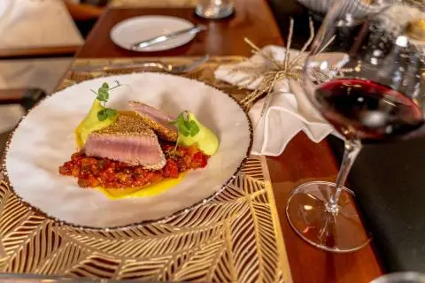 Freedom yacht dining table with plated fish, lemon wedge, and wine glasses