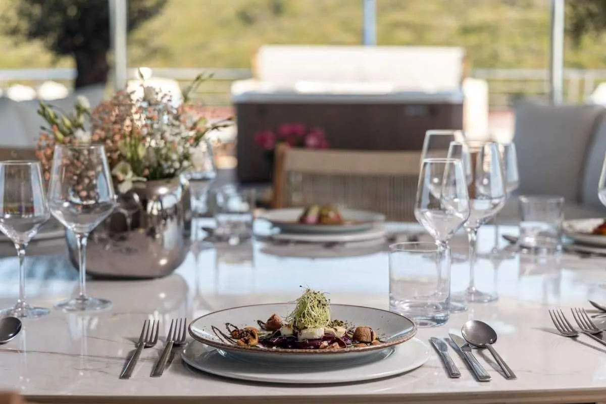 Olimp yacht table set for dining on deck with plates, glasses, and napkins