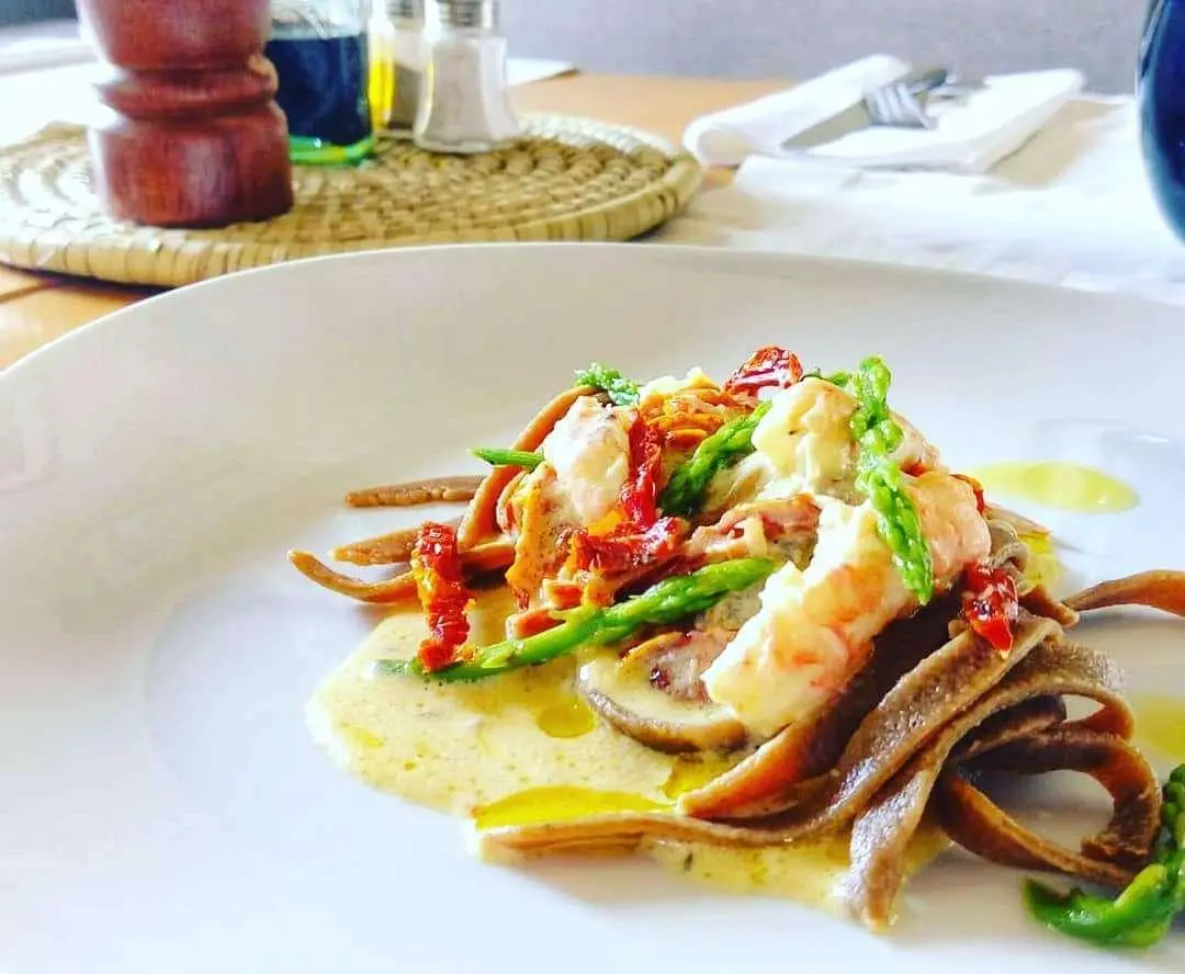 Omnia yacht charter image showing plated lobster and crackers on a dining table