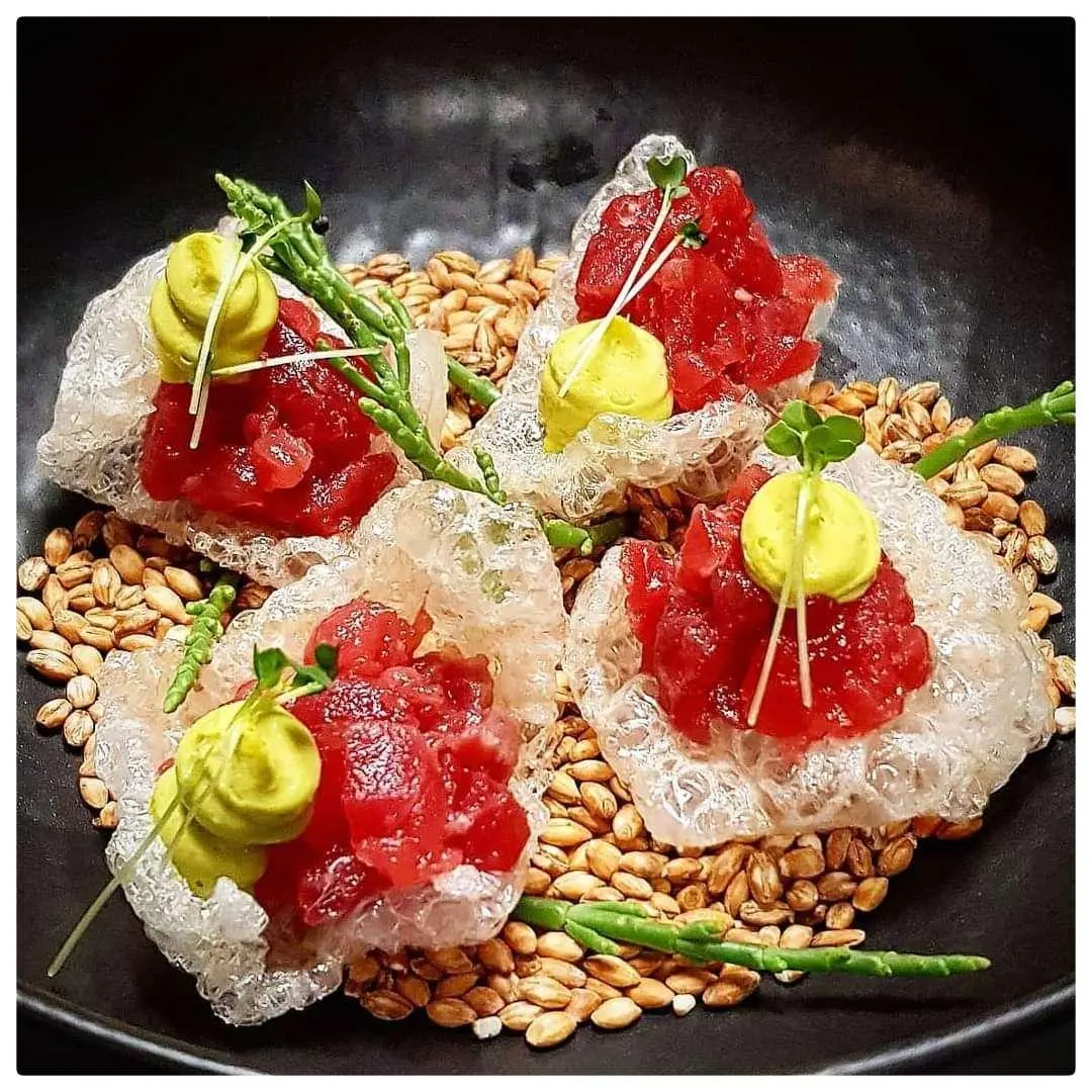 Omnia yacht charter image showing a plate of assorted colorful sushi and garnishes on a dark background