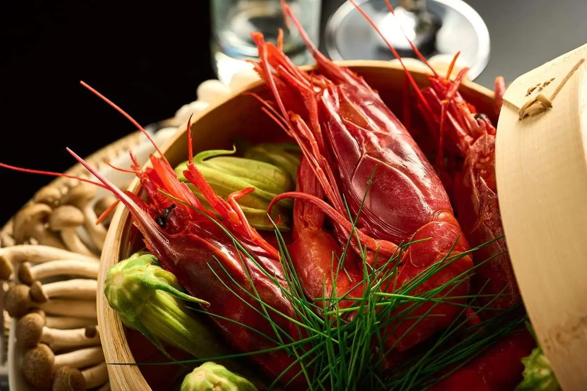 Close-up of red lobster claws and greens on a yacht menu display