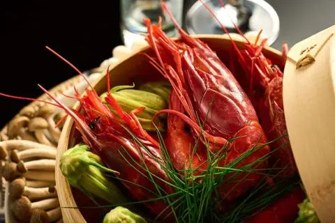 Close-up of red lobster claws and greens on a yacht menu display
