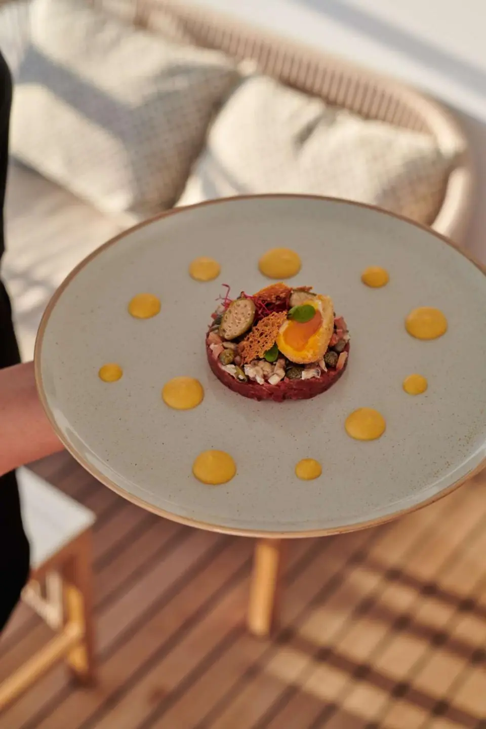 Plate with pastry and lemon slices on a yacht deck table
