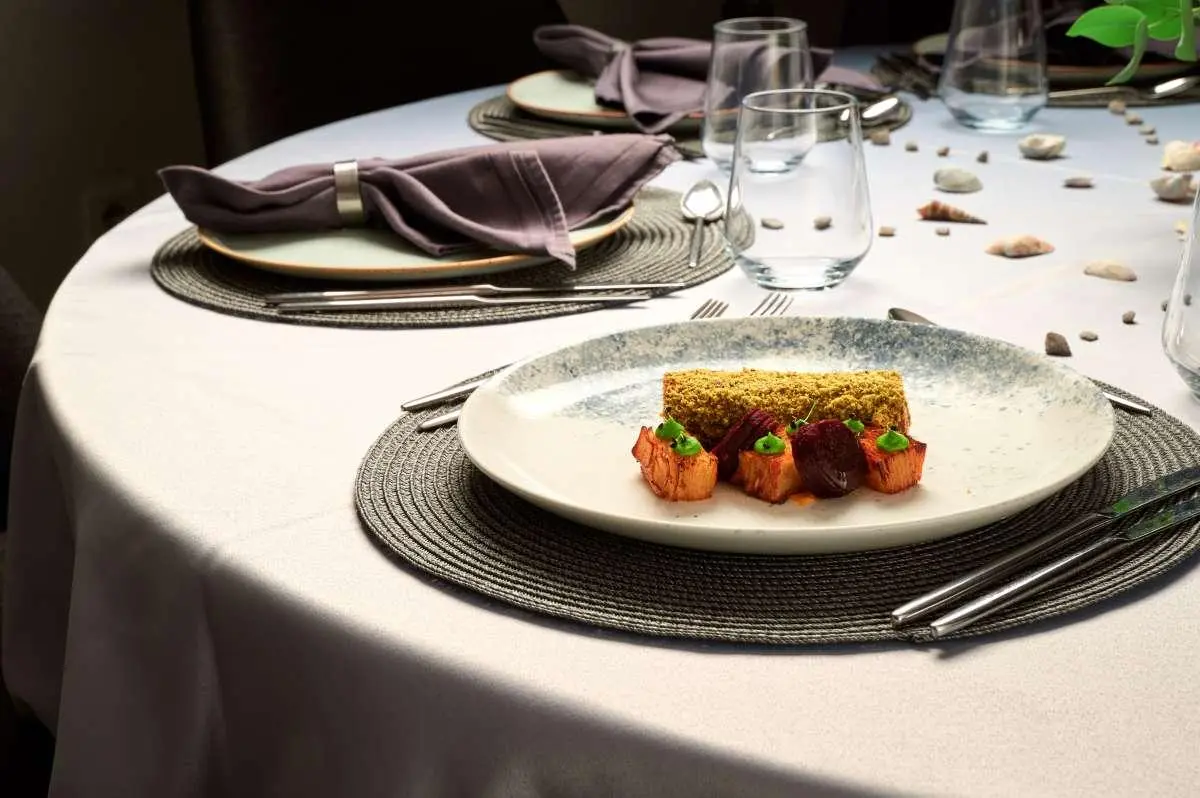 Lupus Mare yacht table setting with plated dish, wine glasses, and elegant dinnerware