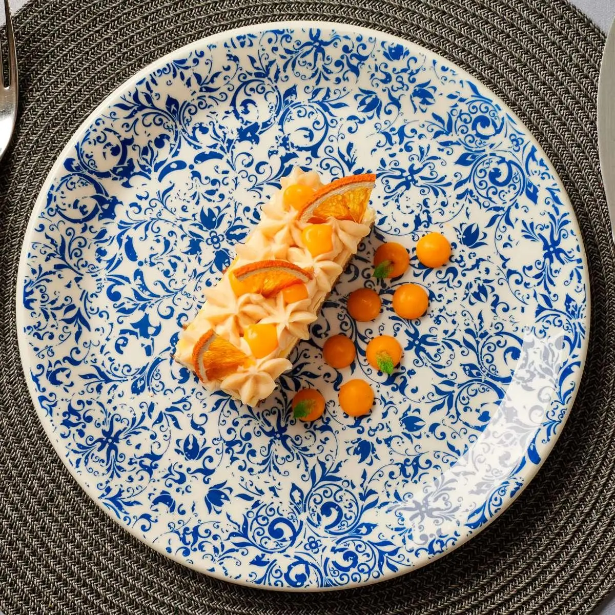 Blue-and-white patterned plate with a rectangular citrus-topped cake and orange dollops