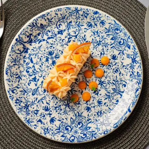 Blue-and-white patterned plate with a rectangular citrus-topped cake and orange dollops