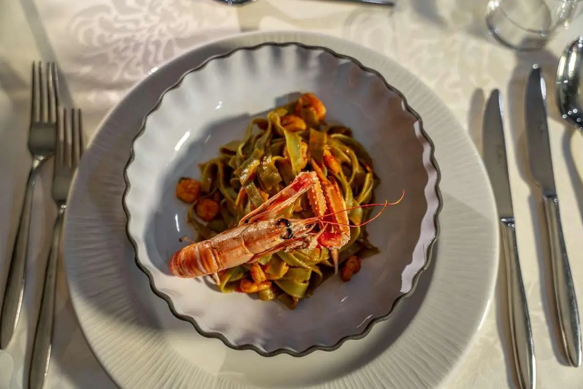 Yacht Karizma dish on a wavy plate with colorful garnish and seafood