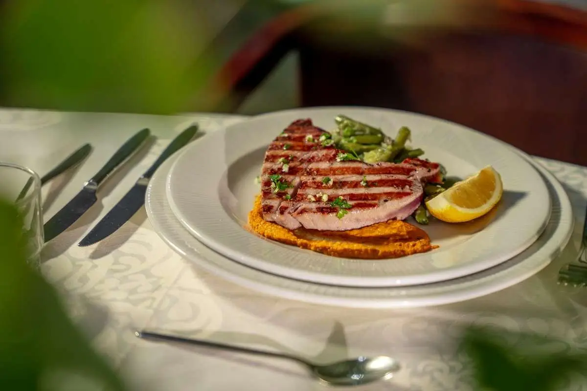 Plate with toasted sandwich and lime wedge on table aboard Karizma yacht
