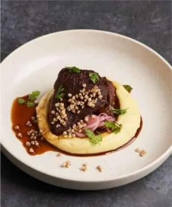 Navilux yacht menu dish on plate: seared meat with sauce and garnish