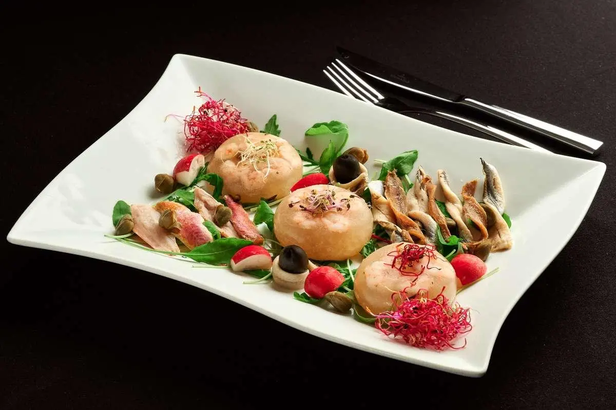 Luna yacht dining plate with assorted seafood and herbs on a white dish
