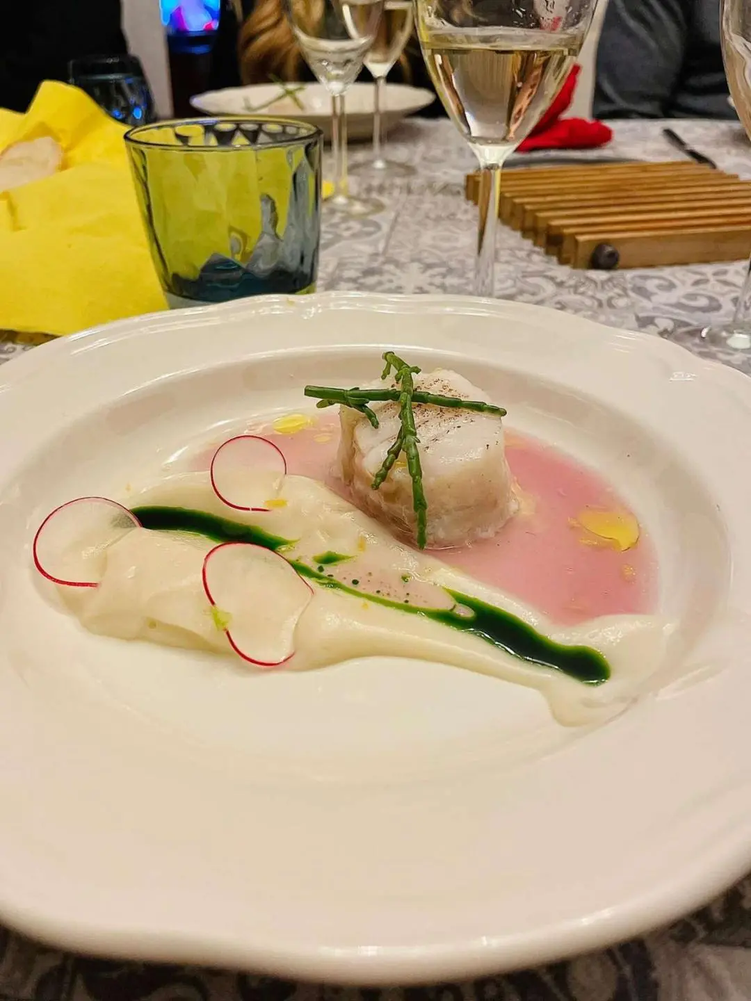Genny yacht dinner plate with sliced fish, greens, and lemon slice on a table