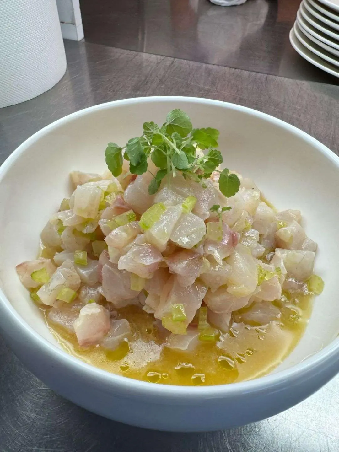 Diced fish dish in a light sauce served in a shallow white bowl