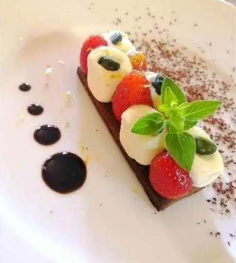 Cartouche yacht sample menu plated dessert on deck with garnish and sauce dots