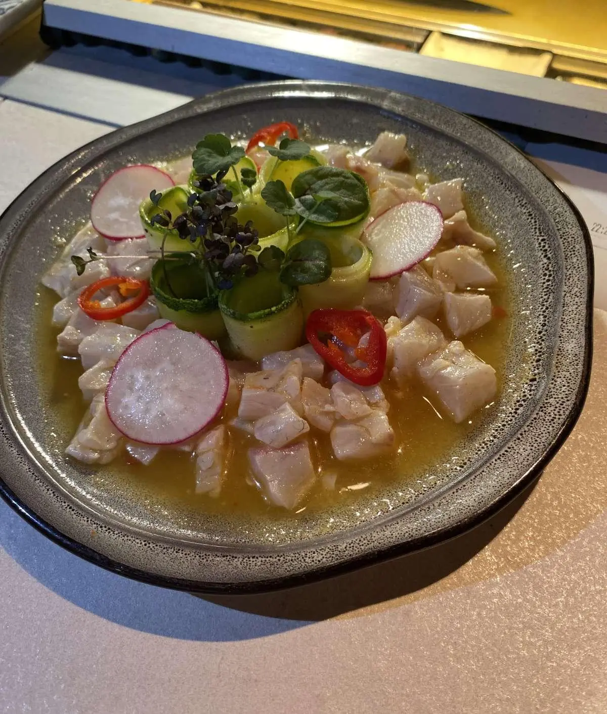 Close-up view of a plate with a colorful seafood salad and greens on a yacht table