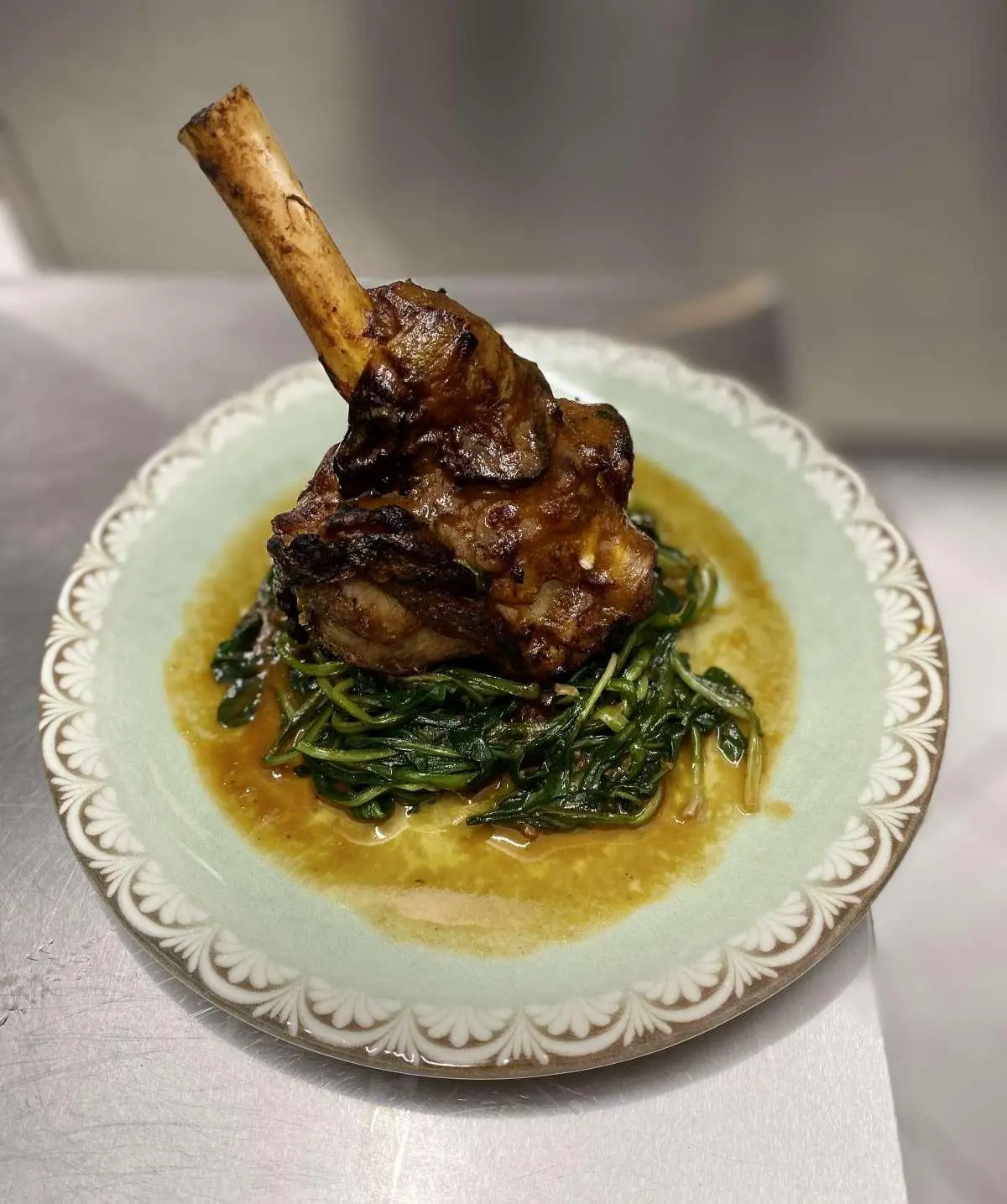 Yacht Christal Mio menu dish on plate with bone-in rib, green sauce