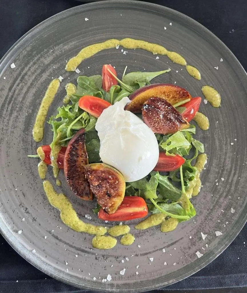 Astoria yacht charter menu on a plate with salad and colorful toppings