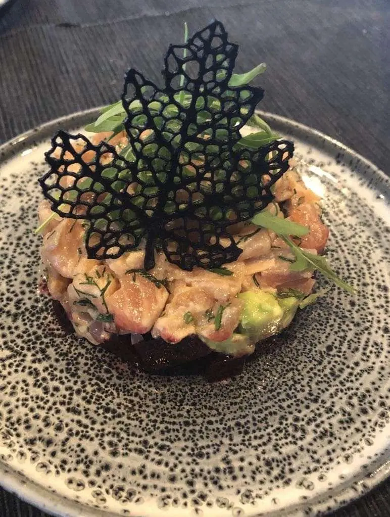Astoria yacht charter dish with tuna tartare plated on dark textured plate