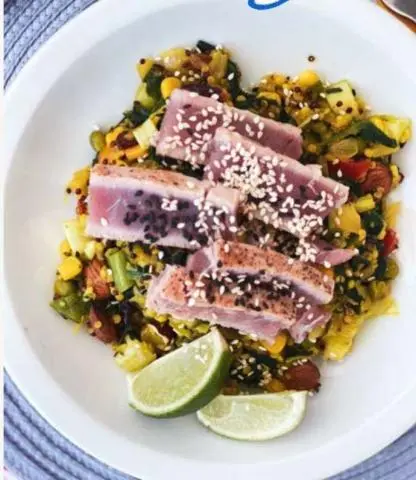 Ocean Lounge yacht passenger dining on deck with plated tuna steak and lime wedge