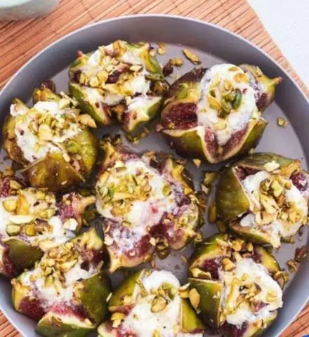 Fig and goat cheese stuffed figs with crushed pistachios on a plate