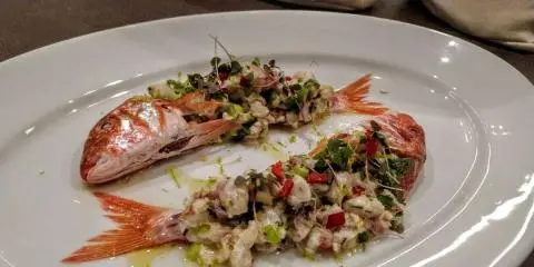 Atlantis yacht charter image showing a plate of mixed seafood dishes on a wooden table